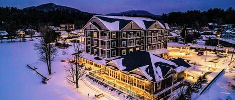 A large, multi-story hotel with a snow-covered roof and a well-lit exterior.