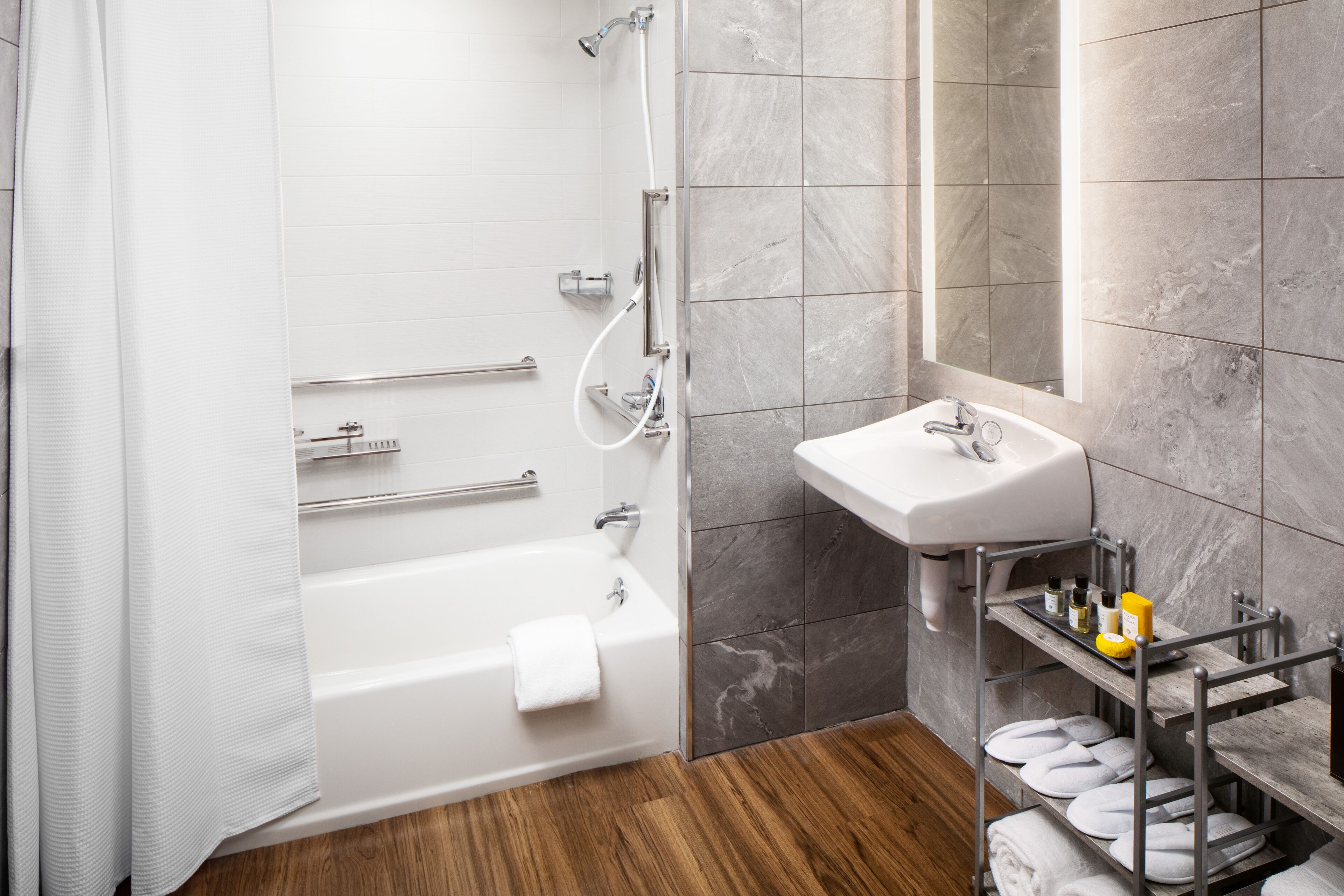 A modern bathroom with a bathtub, shower, and sink.