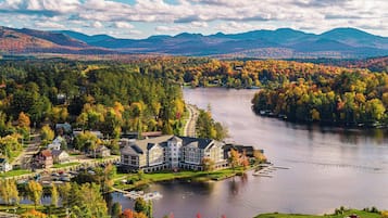 Ett stort hotell med flera byggnader, en sjö och omgivande höstfärgat lövverk.