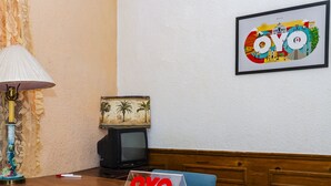A hotel room with a wooden desk, a laptop, a television, a lamp, and a framed picture on the wall. - OYO Hotel Miramar, Loreto (Loreto)