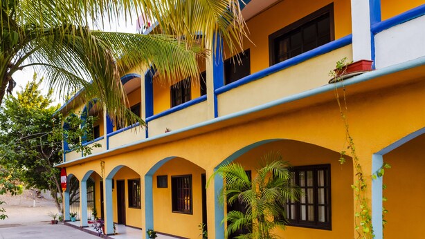 A two-story building with a yellow facade, blue trim, and multiple windows. - OYO Hotel Miramar, Loreto (Loreto)