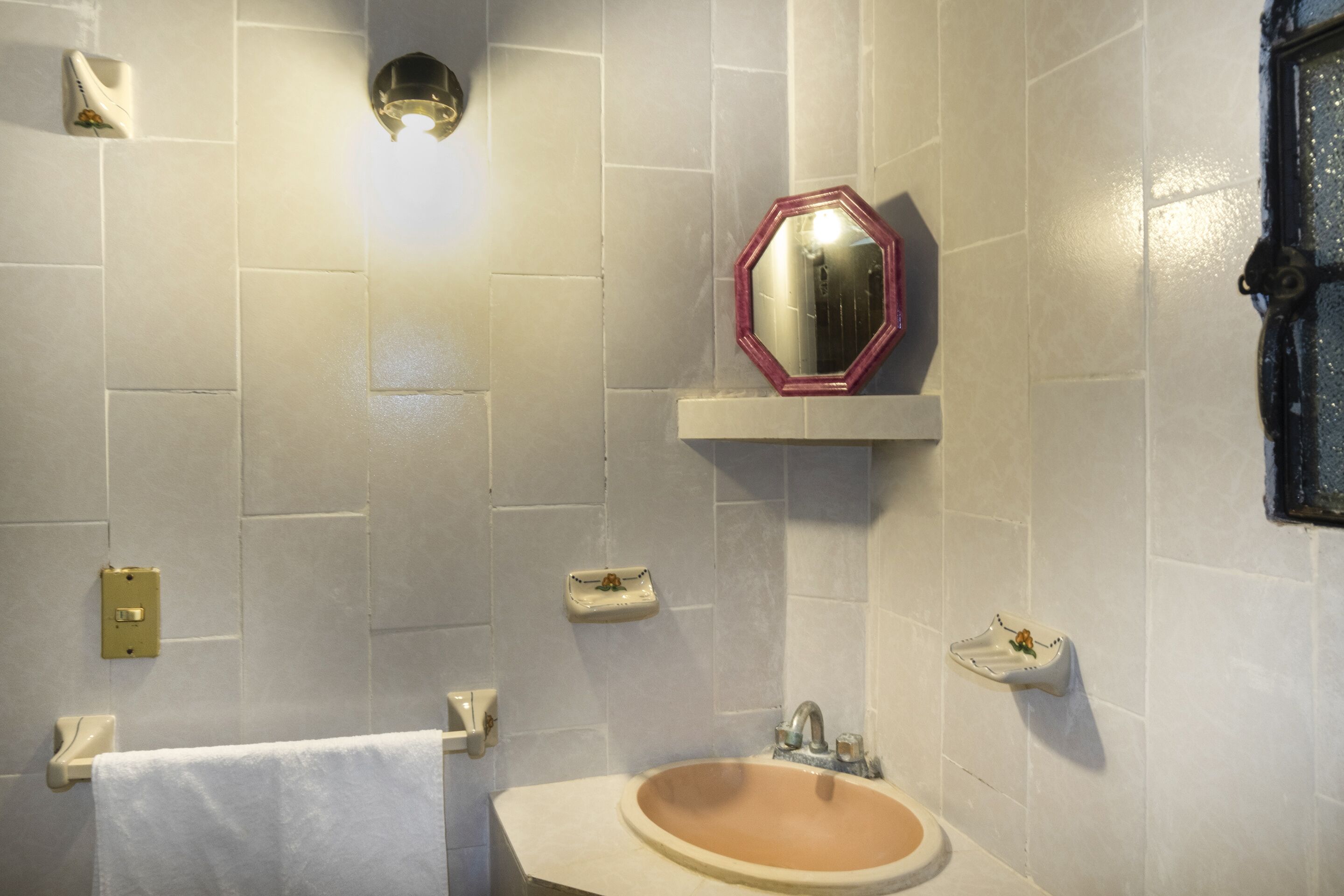 A bathroom with a sink, mirror, and towel rack.