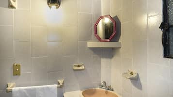 A bathroom with a sink, mirror, and towel rack.
