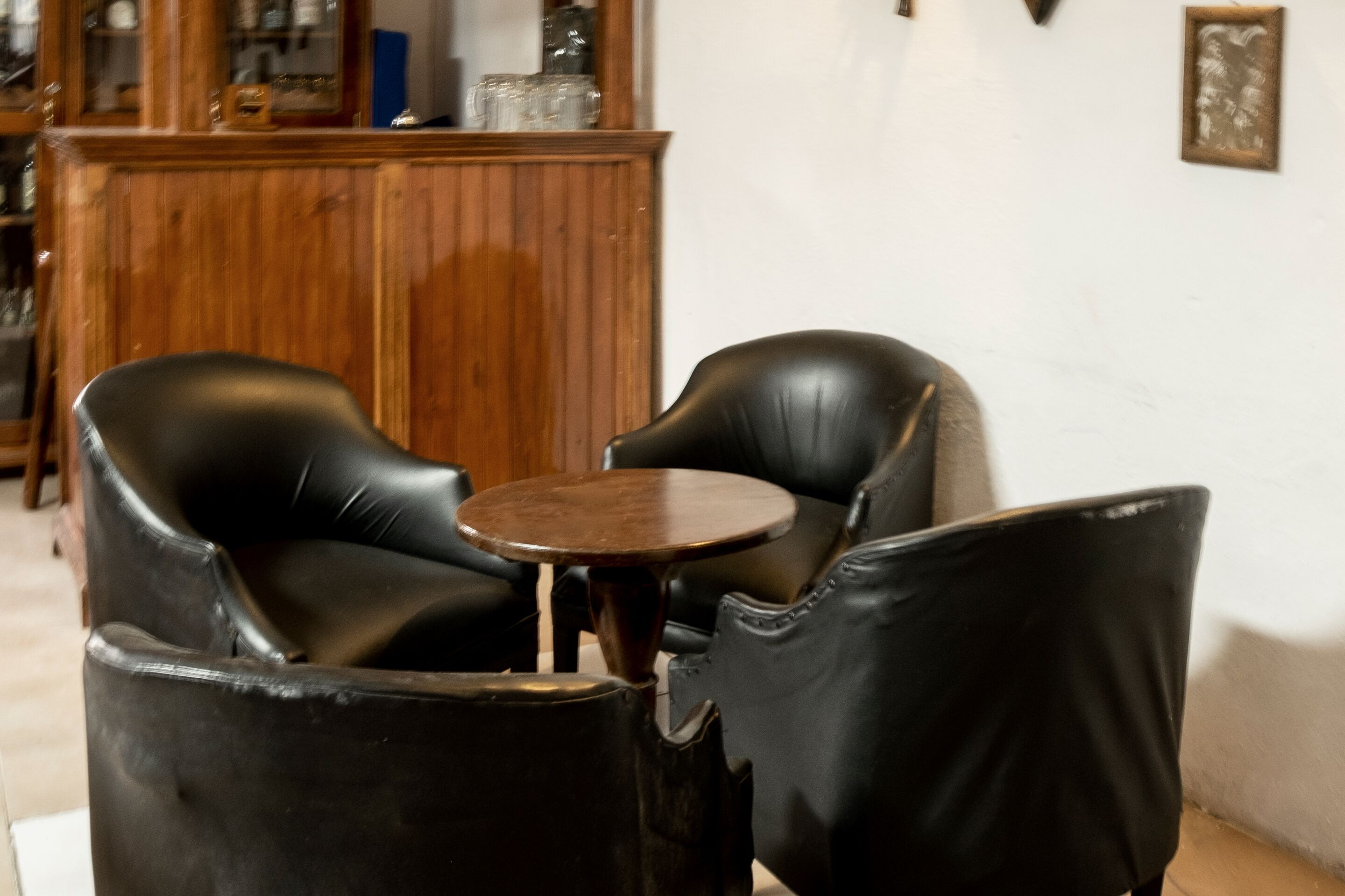 Una habitación con dos sillones de cuero negro y una mesita redonda.