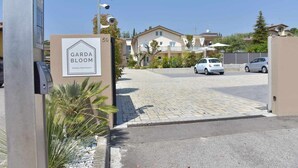 A gated entrance to a residential area with a sign for 'Garda Bloom Holiday Apartments.'