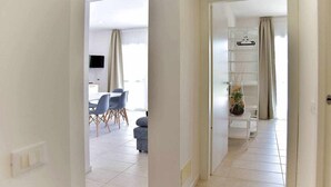Un interior moderno con comedor, sala de estar y un pasillo que conduce a otra habitación.