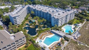 A large hotel with multiple buildings, a central swimming pool, and surrounding greenery. - Oceanfront Penthouse Villa w/ Balcony, Hilton Head (Hilton Head Island)