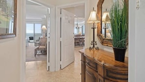A hallway with a wooden dresser, a mirror, and a potted plant. - Oceanfront Penthouse Villa w/ Balcony, Hilton Head (Hilton Head Island)