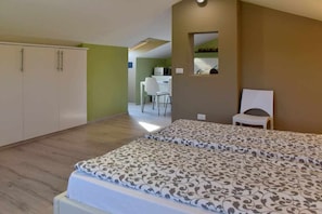 A bedroom with a bed, a desk, and a chair.