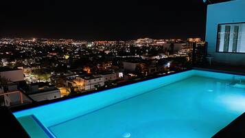 Una piscina al aire libre, sillones reclinables de piscina