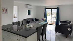 Un apartamento moderno con cocina, comedor y balcón con vistas a la ciudad.