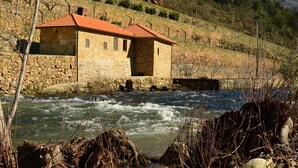 Un edificio de piedra con techo rojo cerca de un río.