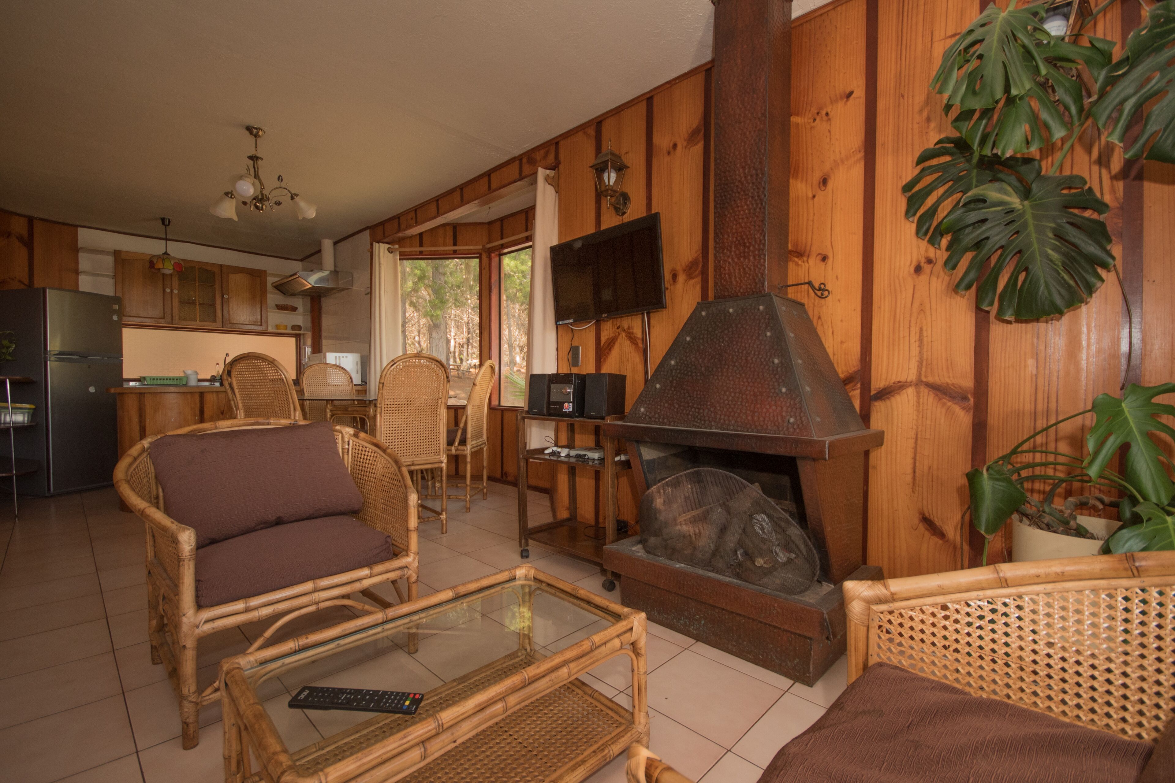 Interior acogedor de una cabaña con comedor, cocina y chimenea.