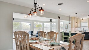 Un coin repas avec une table en bois dressée pour six personnes, entourée de chaises assorties.