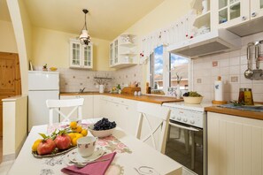 Enjoy meals in this kitchen with an oven and range hood, perfect for cooking and dining.