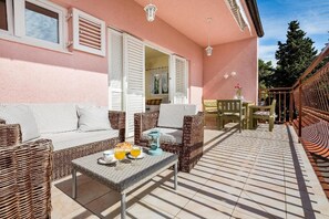 Relax in this inviting outdoor seating area with a wicker sofa and table set.