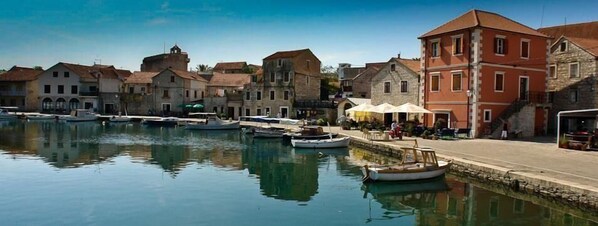 Traditional waterfront buildings line the serene shore, offering a tranquil atmosphere.