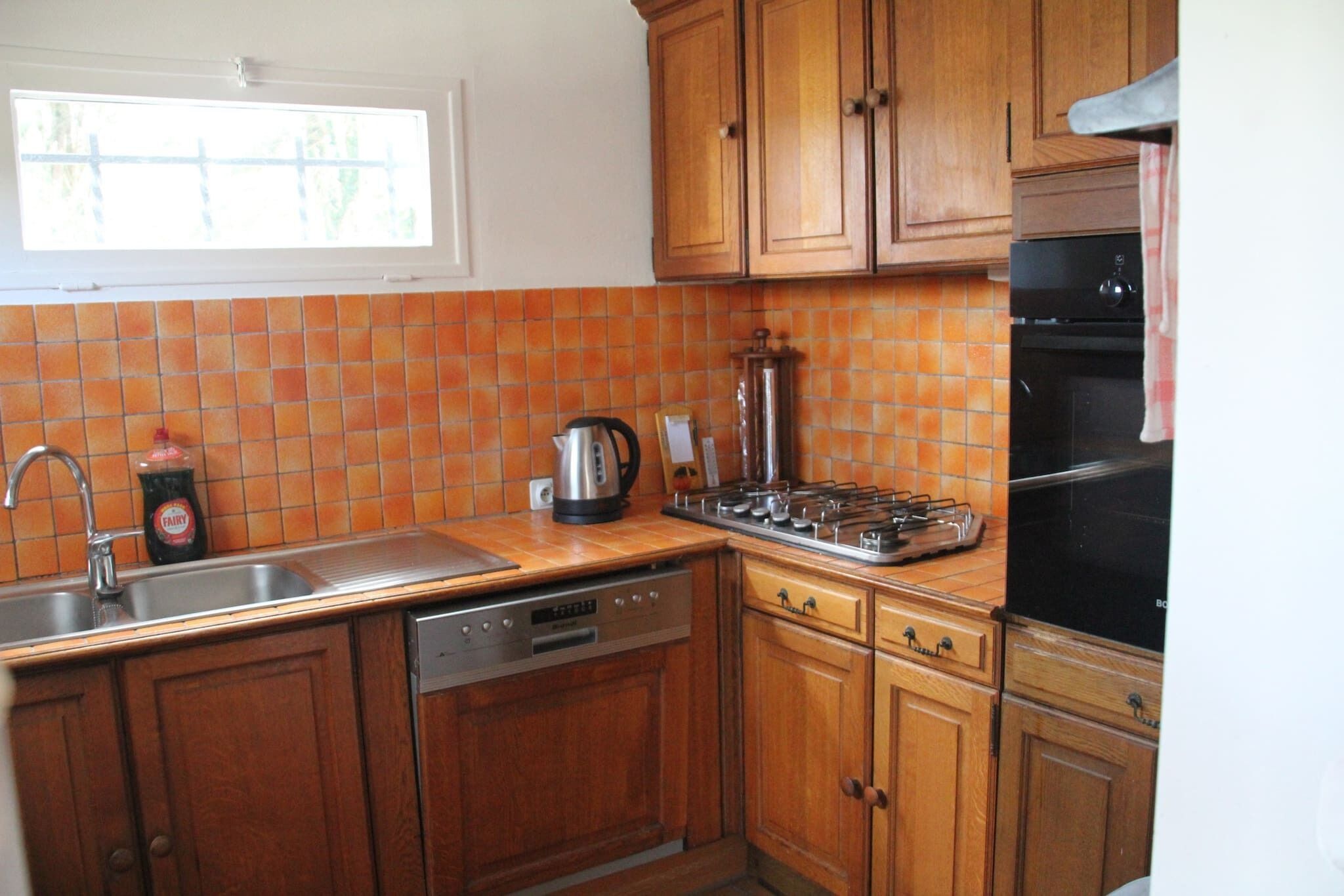 A kitchen with wooden cabinets, a dishwasher, a stove, and a sink.