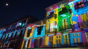 A row of brightly lit buildings with balconies and windows, likely part of a hotel or residential area.