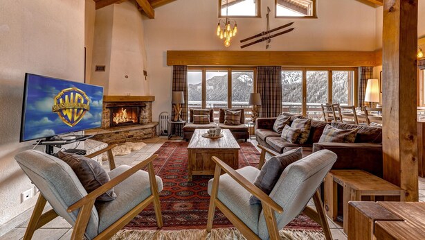 A cozy living room with a fireplace, comfortable seating, and large windows offering a view of the outdoors. - Chalet Coeur - Jacuzzi - Sauna - Views - La Tzoumaz, 4 Vallees (La Tzoumaz)