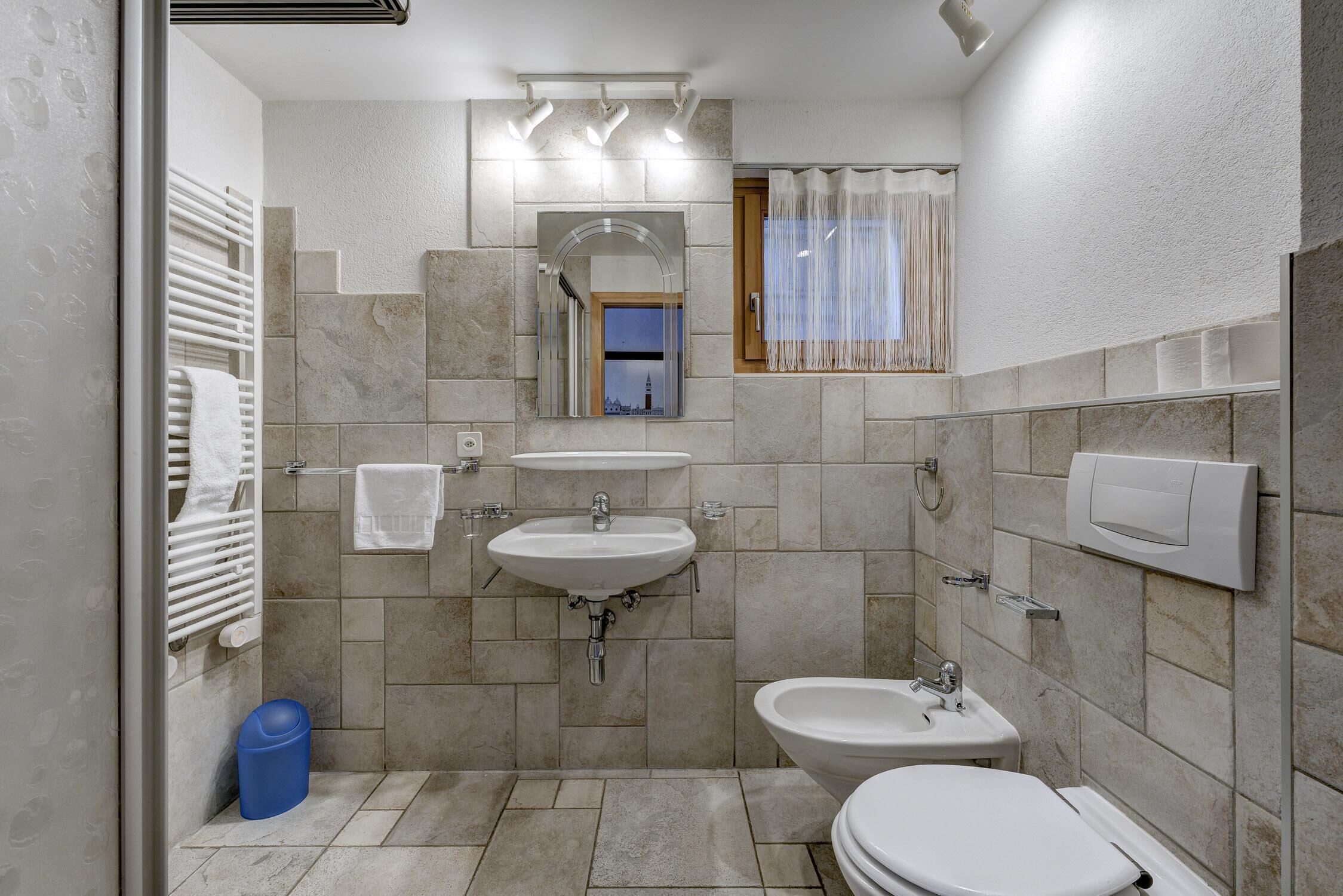 A modern bathroom with a bathtub, two sinks, a toilet, and a shower.