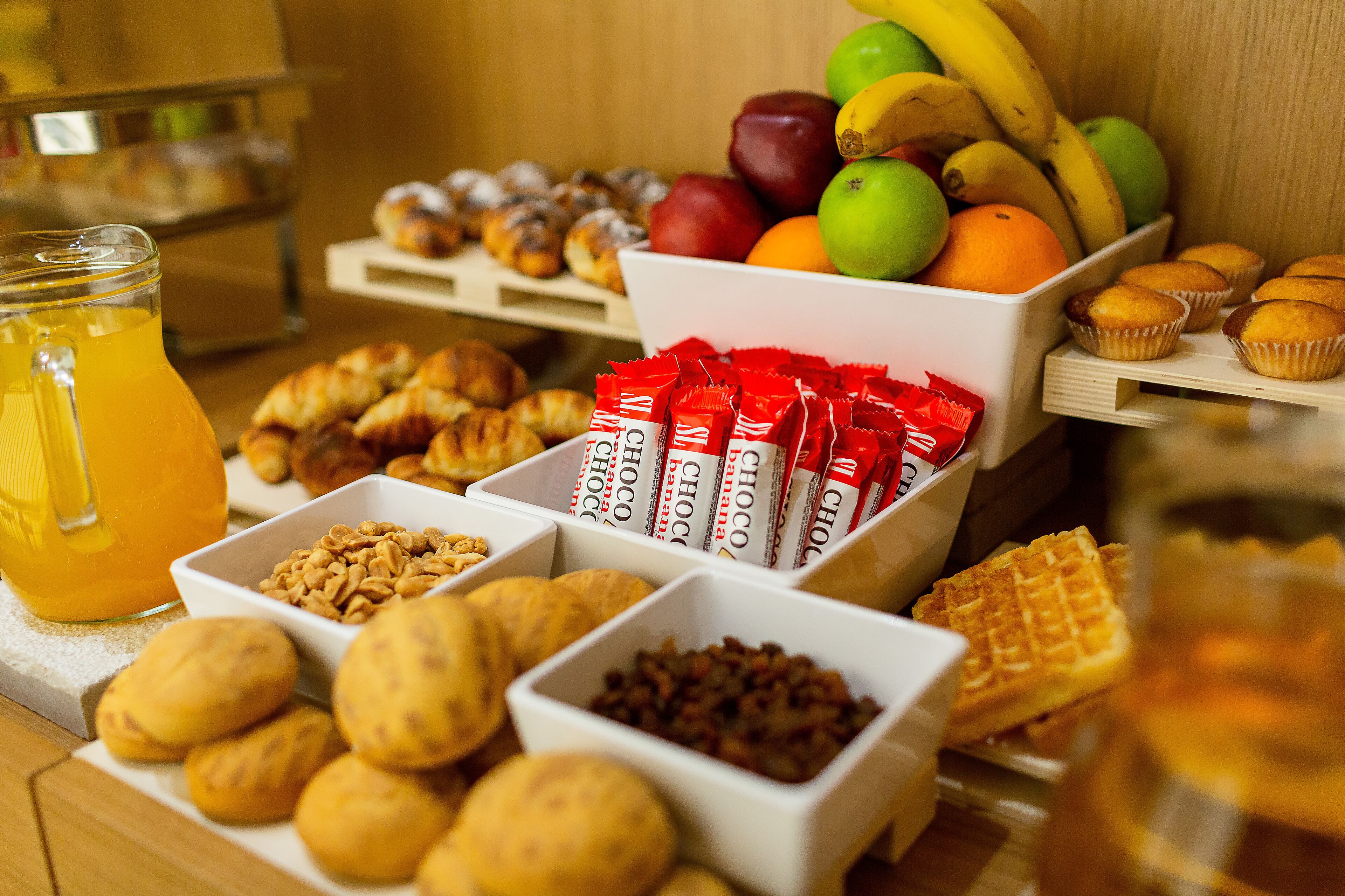 Ein Frühstücksbuffet mit einer Auswahl an Backwaren, Früchten und Getränken.