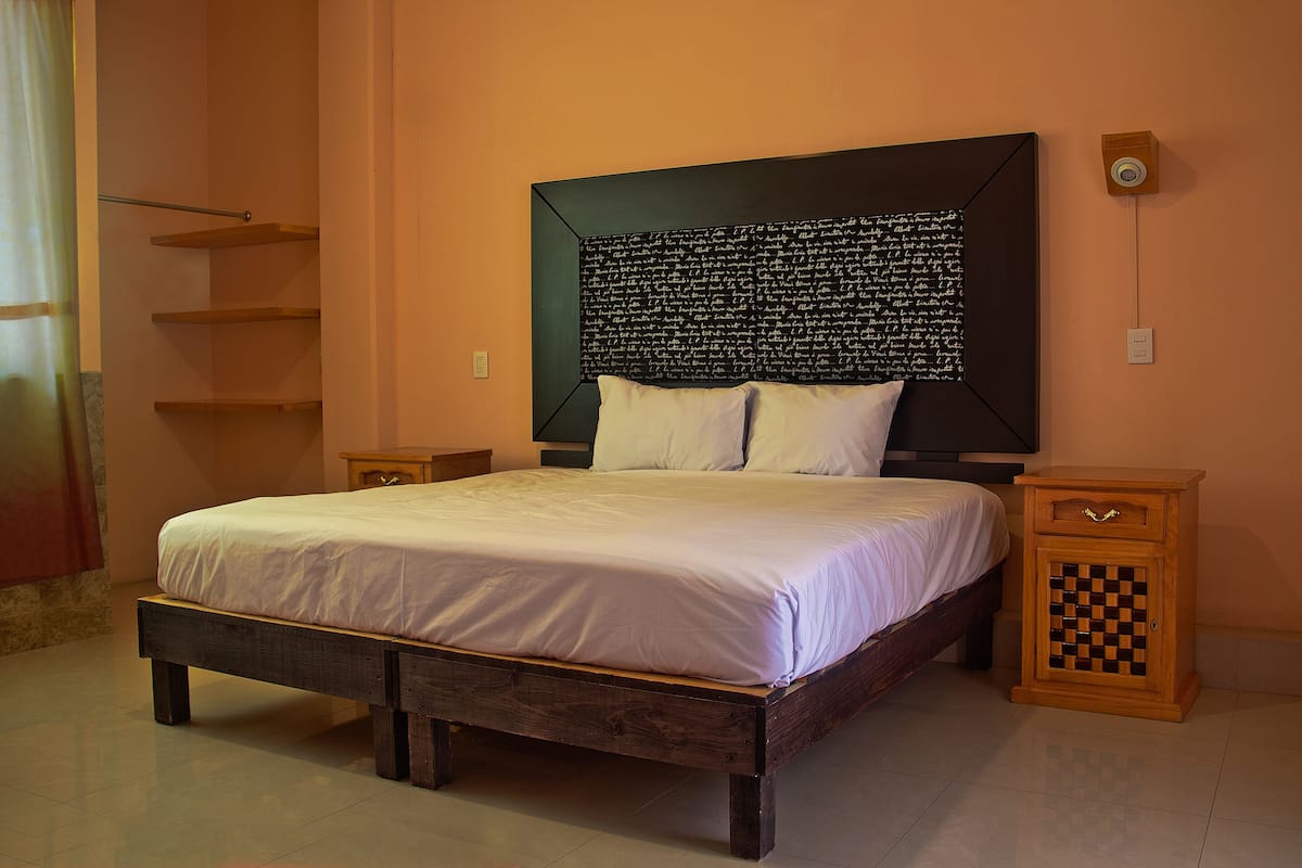 Ein Schlafzimmer mit einem Bett, einem Nachttisch und einem an der Wand befestigten Lautsprecher.