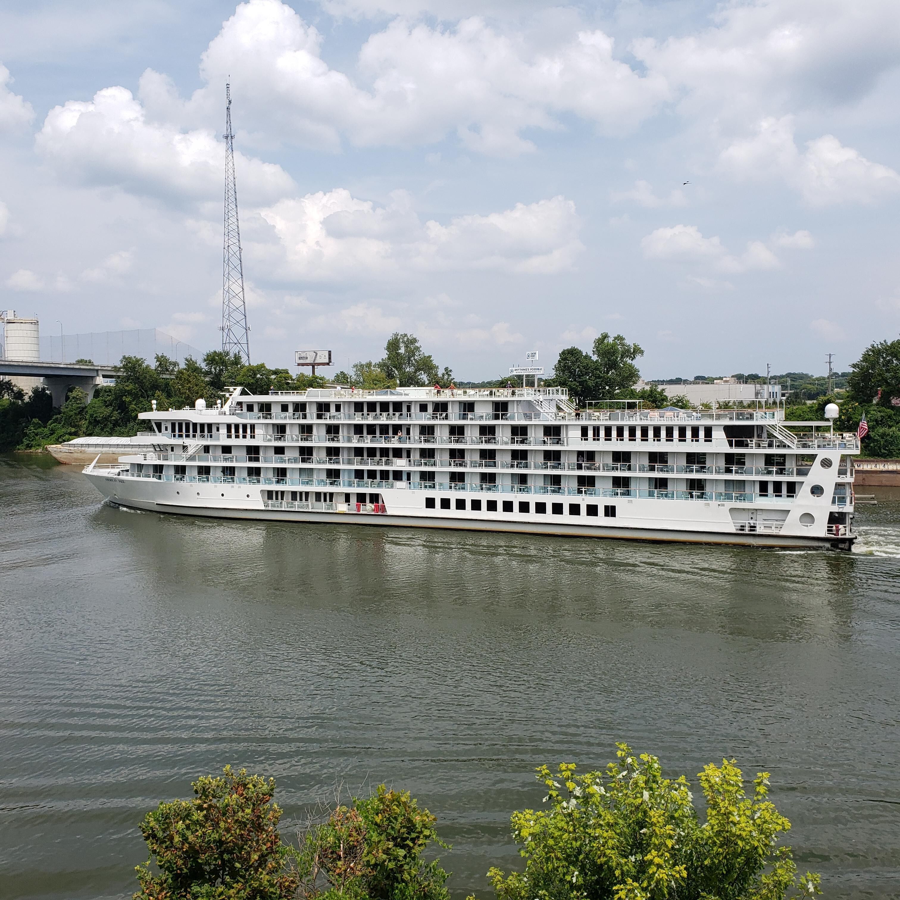A large river cruise ship with multiple decks and a white exterior.
