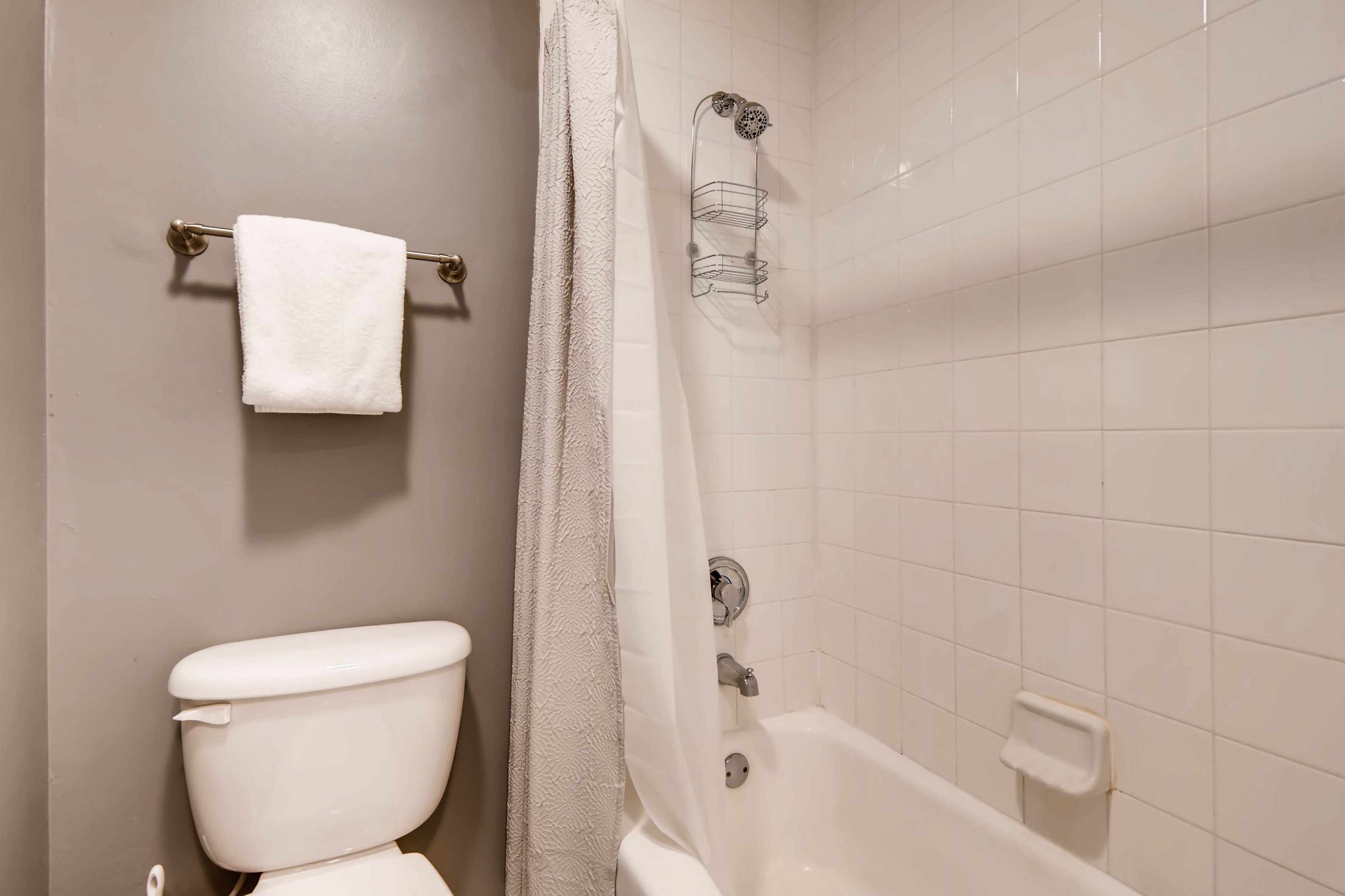 Ein Badezimmer mit Toilette, einer Dusche mit Glaswand und einem Handtuchhalter.