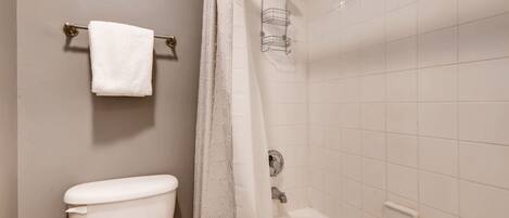 Ein Badezimmer mit Toilette, einer Dusche mit Glaswand und einem Handtuchhalter.