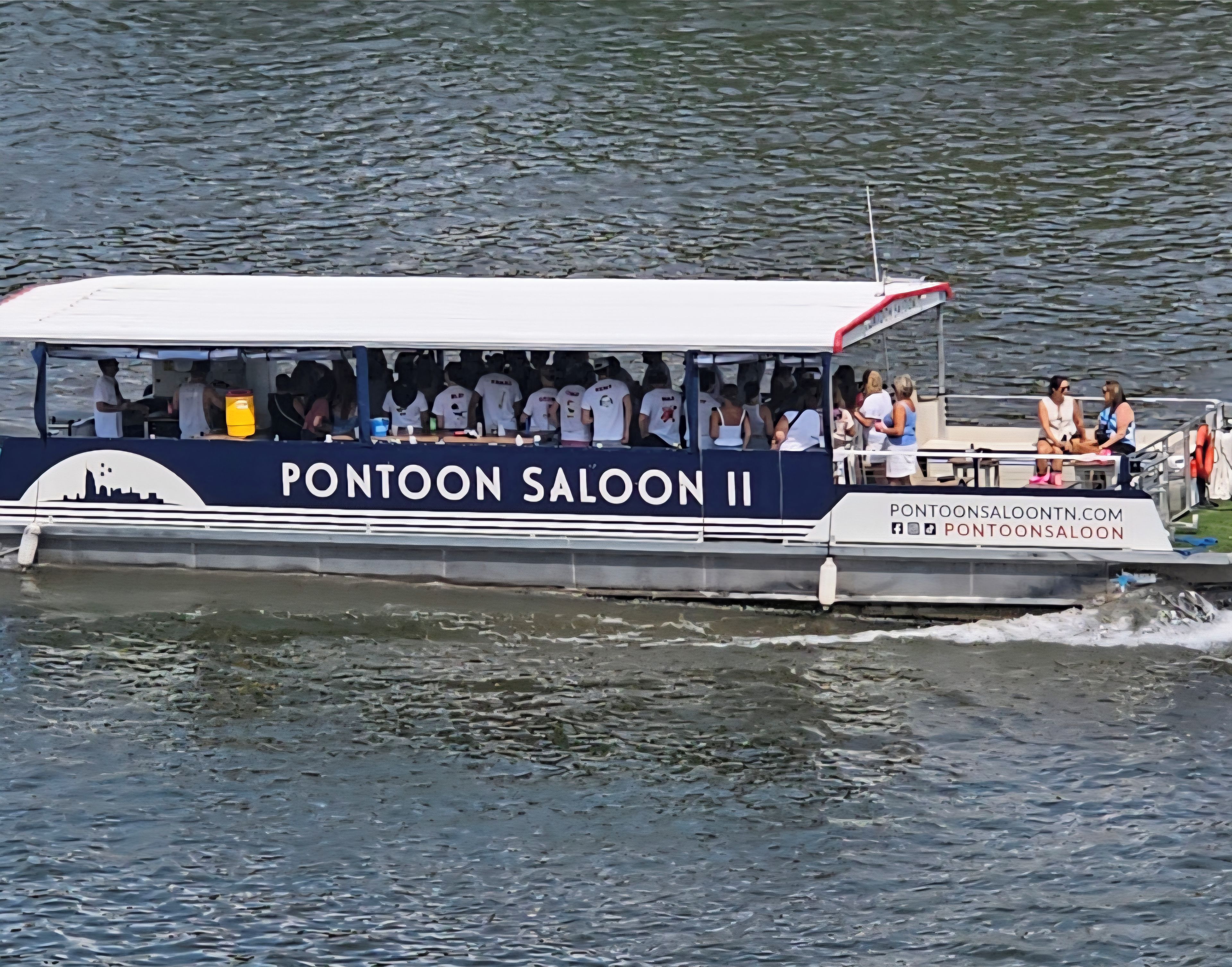 Una lancha con el nombre 'PONTOON SALOON II' y la dirección web 'PONTOONSALOOON.COM'.