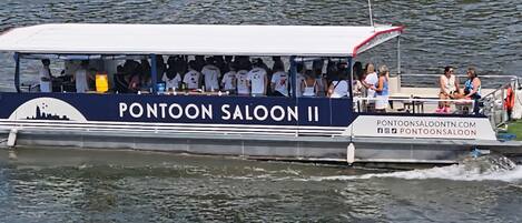 Una lancha con el nombre 'PONTOON SALOON II' y la dirección web 'PONTOONSALOOON.COM'.