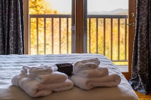 A bed with folded towels and a black item labeled 'Makeup' on it.