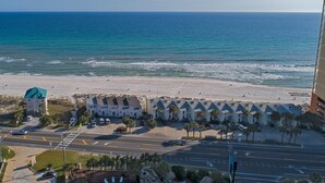 Un hôtel situé sur la côte, avec vue sur la plage, composé de plusieurs bâtiments et disposant d’un parking.
