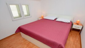A bedroom with a bed, two bedside tables, a window, and a nightstand with a lamp. - Apartment Surjan by Interhome (Korčula/Vela Luka)