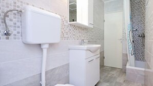 A bathroom with a toilet, sink, and shower area. - Apartment Surjan by Interhome (Korčula/Vela Luka)