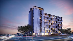 Un edificio moderno de varios pisos con balcones, ventanas amplias y diseño de techo plano.