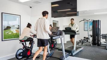 A gym with treadmills, an elliptical, and a stationary bike.