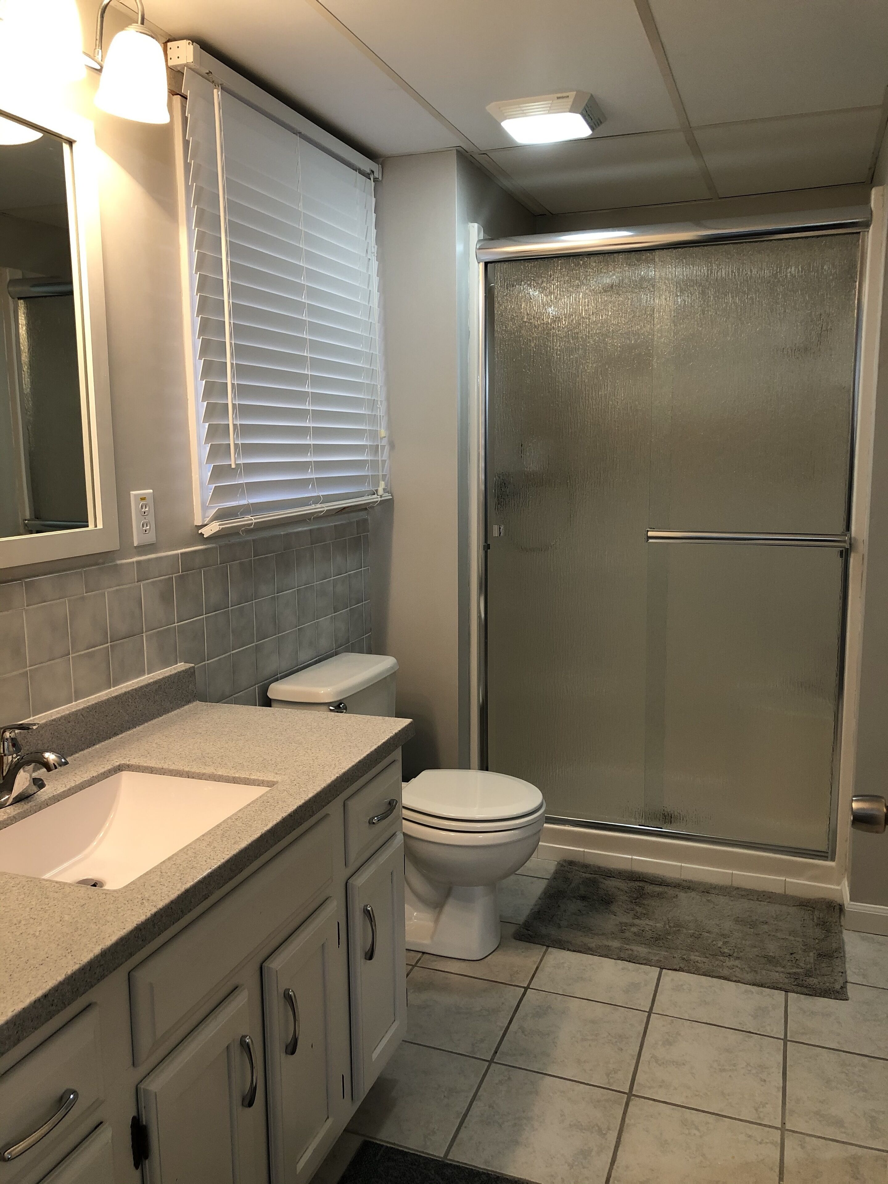Un bagno con lavandino, WC e doccia.