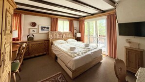 A bedroom with a bed, a desk, a chair, a TV, and a window. - Residenza Chesa Margun 78-1 by Interhome (Silvaplana-Surlej)