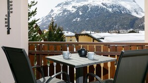 A balcony with a table and chairs, overlooking a snow-covered mountain. - Residenza Chesa Margun 78-1 by Interhome (Silvaplana-Surlej)