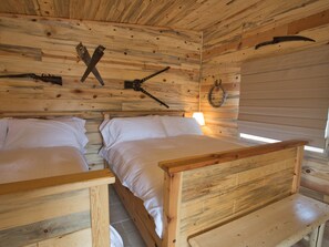 A cabin with two wooden beds, a wooden ceiling, and a rustic interior. - Farriers Quarters Studio on 280 acre Sevier River Ranch - 2 Queen Beds (Hatch)