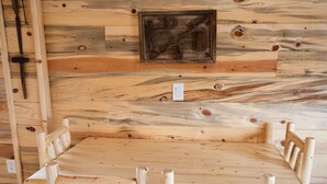 A wooden dining table with chairs, a light switch, and a framed picture on the wall. - Farriers Quarters Studio on 280 acre Sevier River Ranch - 2 Queen Beds (Hatch)