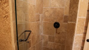 A shower with a glass door, a handrail, and a black showerhead. - Tack Room Studio on 280 acre Sevier River Ranch - 1 King and 2 Twin Beds (Hatch)