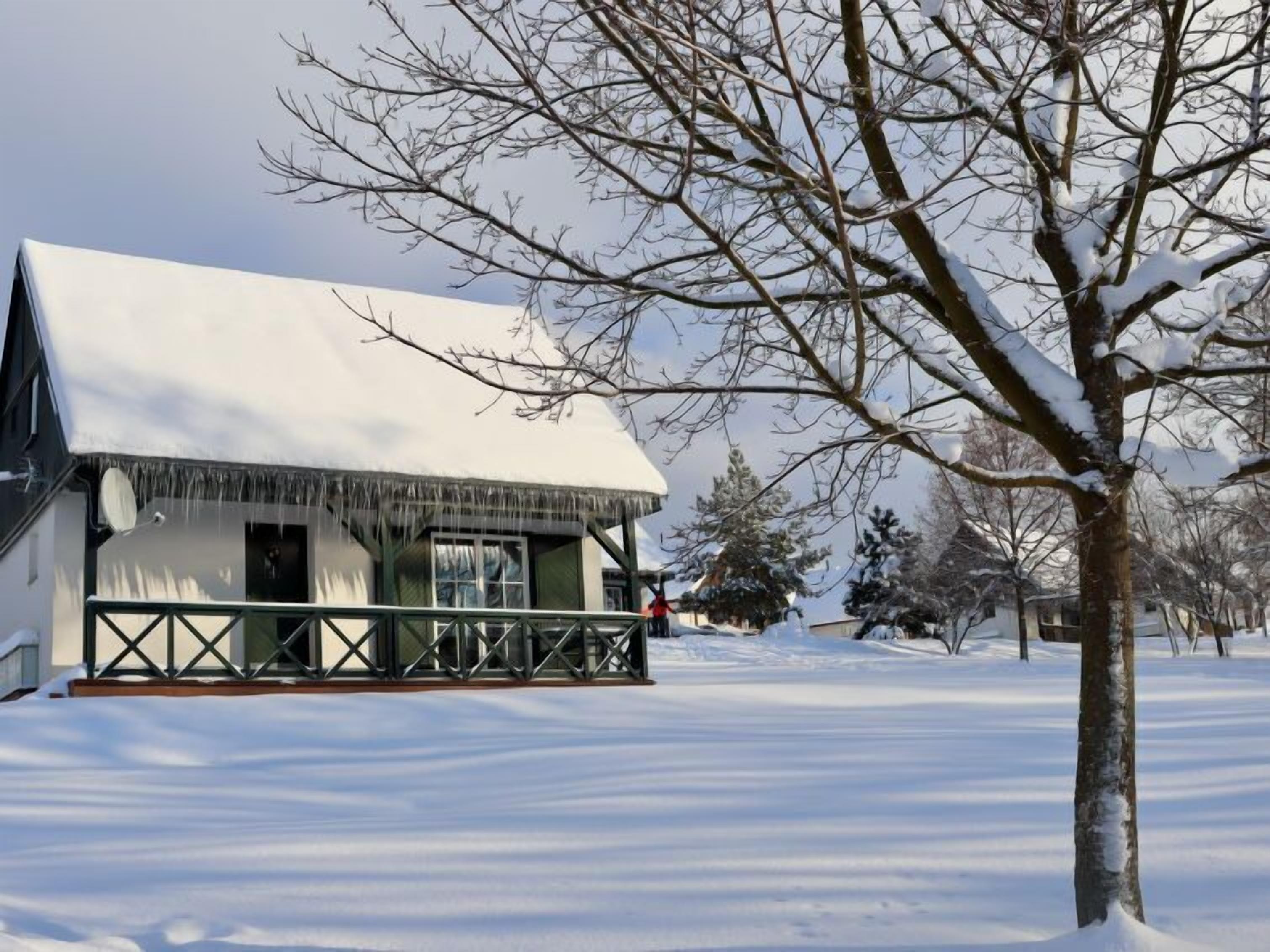 Un bâtiment recouvert de neige, doté d’un balcon et orné de glaçons.