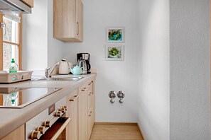 Une cuisine moderne avec des meubles en bois, une machine à café et une bouilloire.