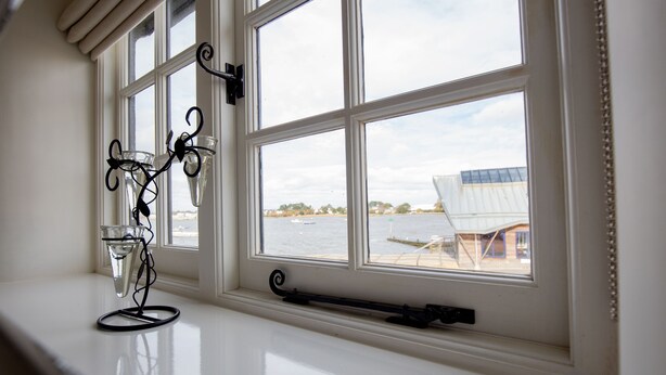 A window with a view of a body of water and a boat. - 'The Old Customs House', character cottage on Mudeford Quay (Christchurch)