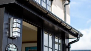 A black metal entrance with a sign reading "The Old Customs House 4". - 'The Old Customs House', character cottage on Mudeford Quay (Christchurch)