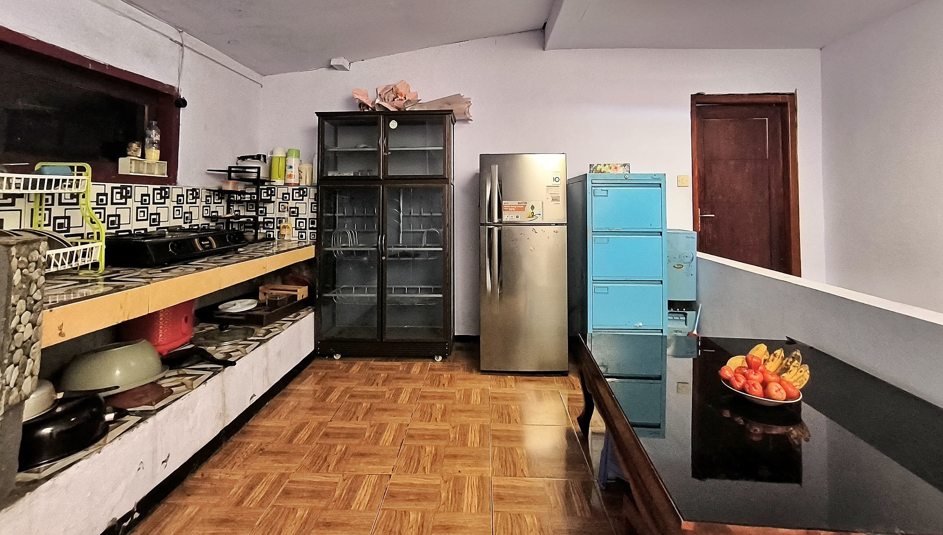 A compact kitchen with a gas stove, oven, refrigerator, and blue cabinets.