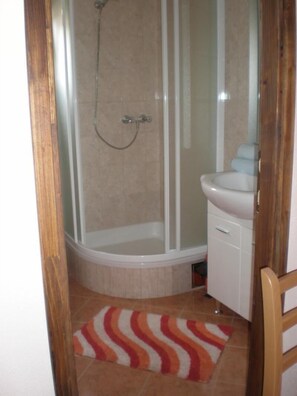 Een douche, handdoeken, toiletpapier